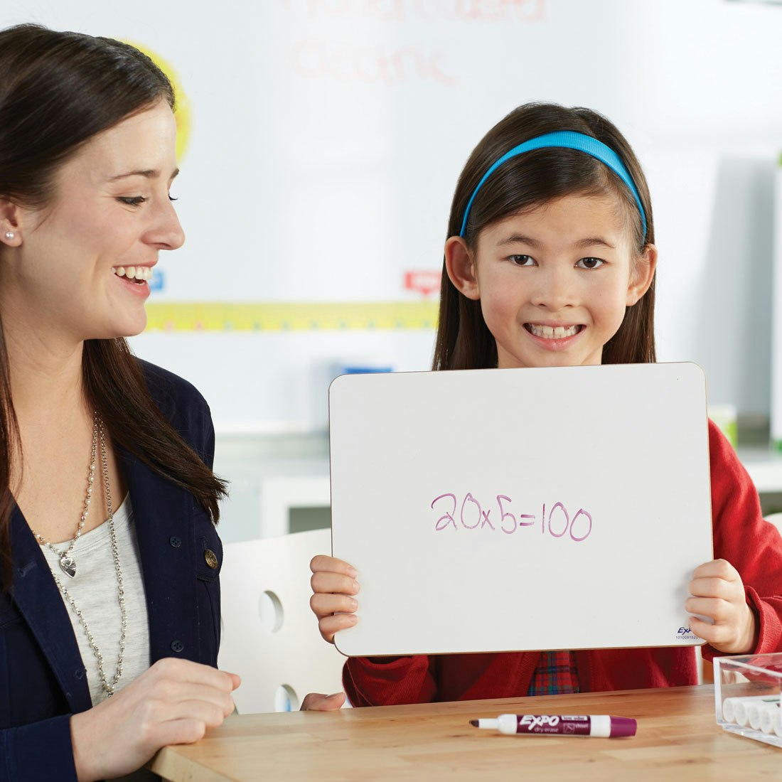 girl-holding-up-whiteboard-with-math-equation-on-it.jpg